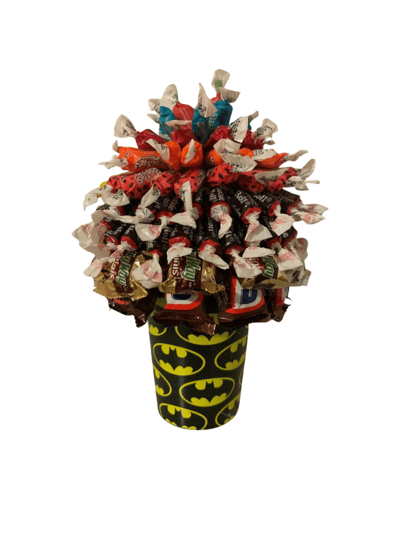 A glass jar filled with colorful candied fruit on a table.