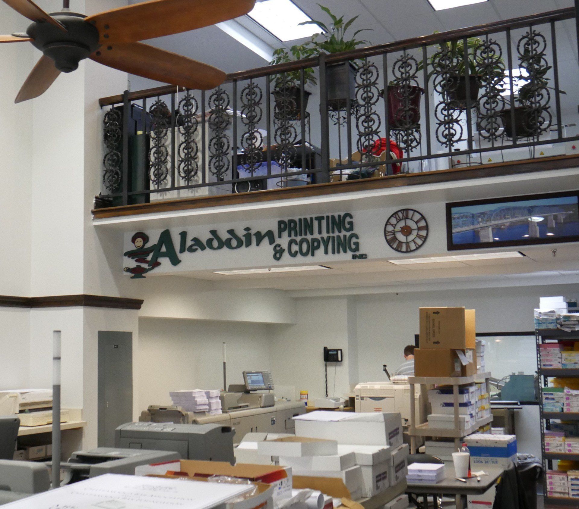 An office with a sign that says aladdin printing and copying