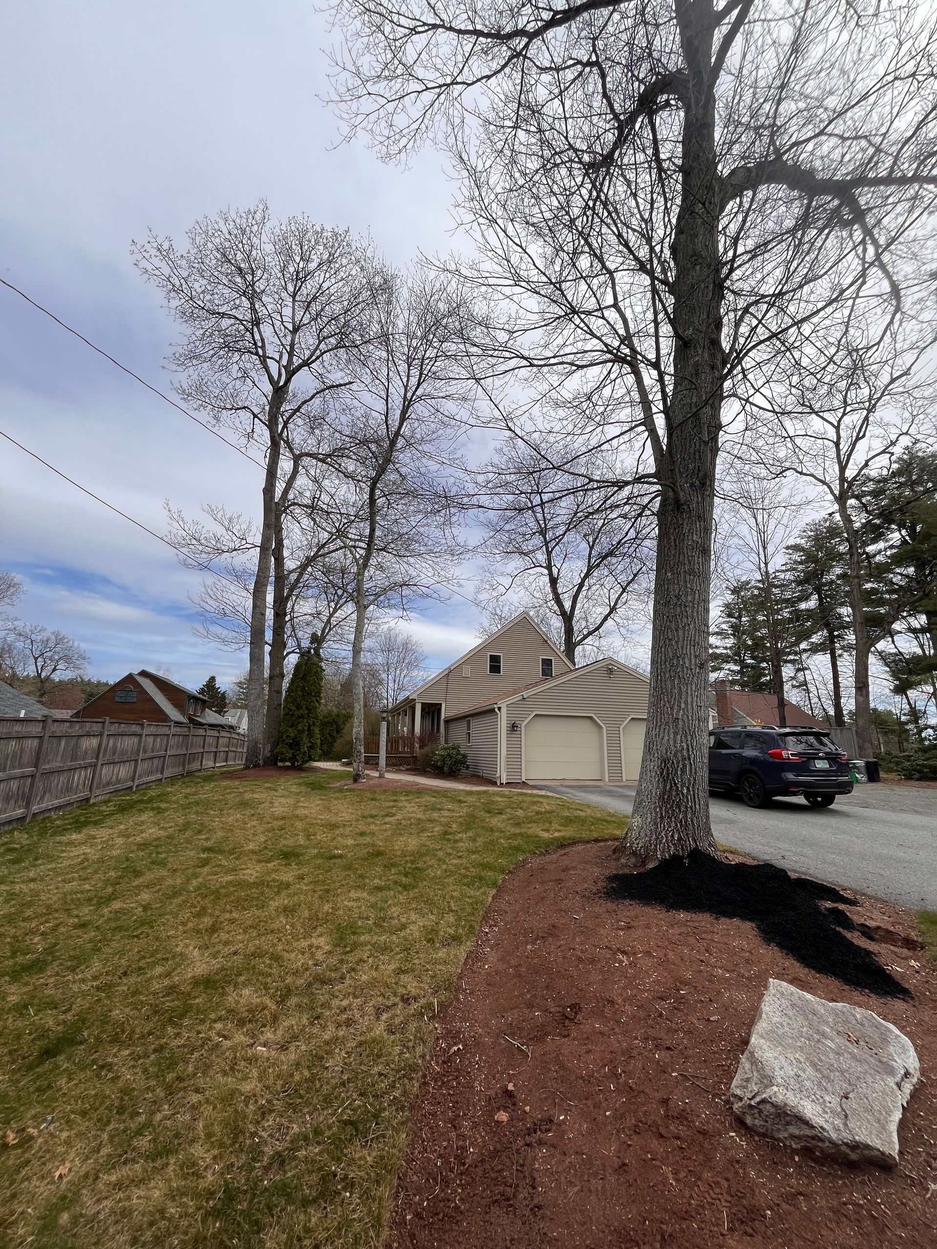 A house with a garage and a car parked in front of it.