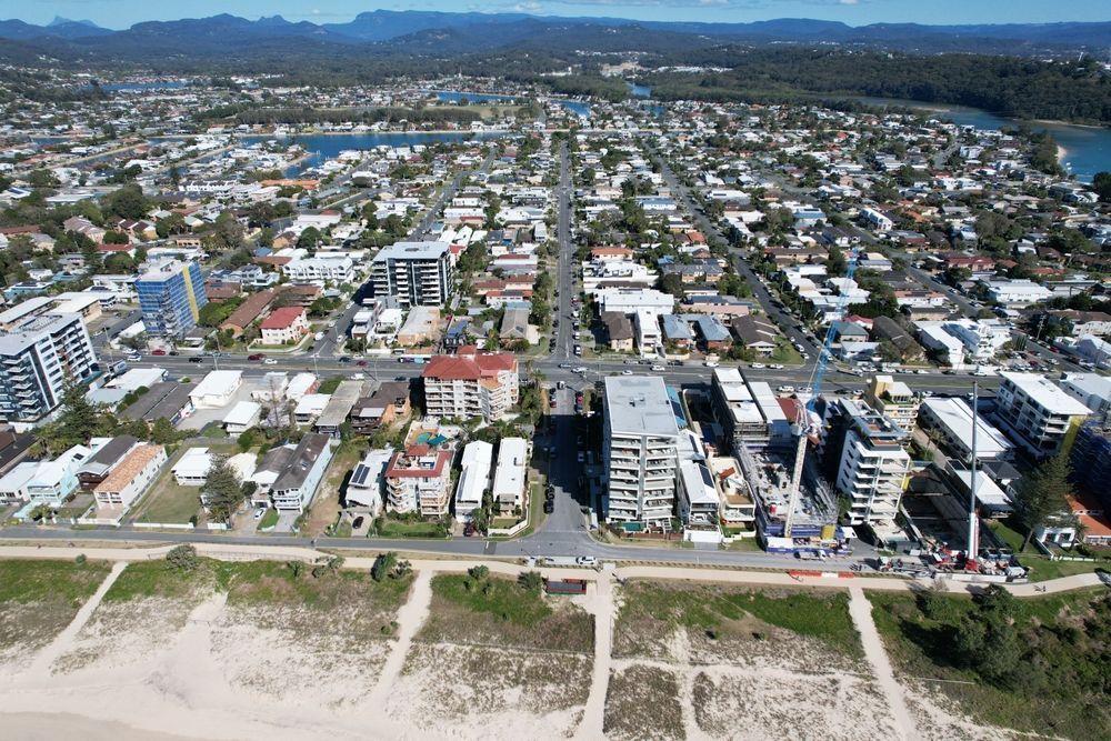 Aerial view of a coastal town with buildings, roads, beach, and water. — Glenn Rowe Auto Electrics in Palm Beach, QLD