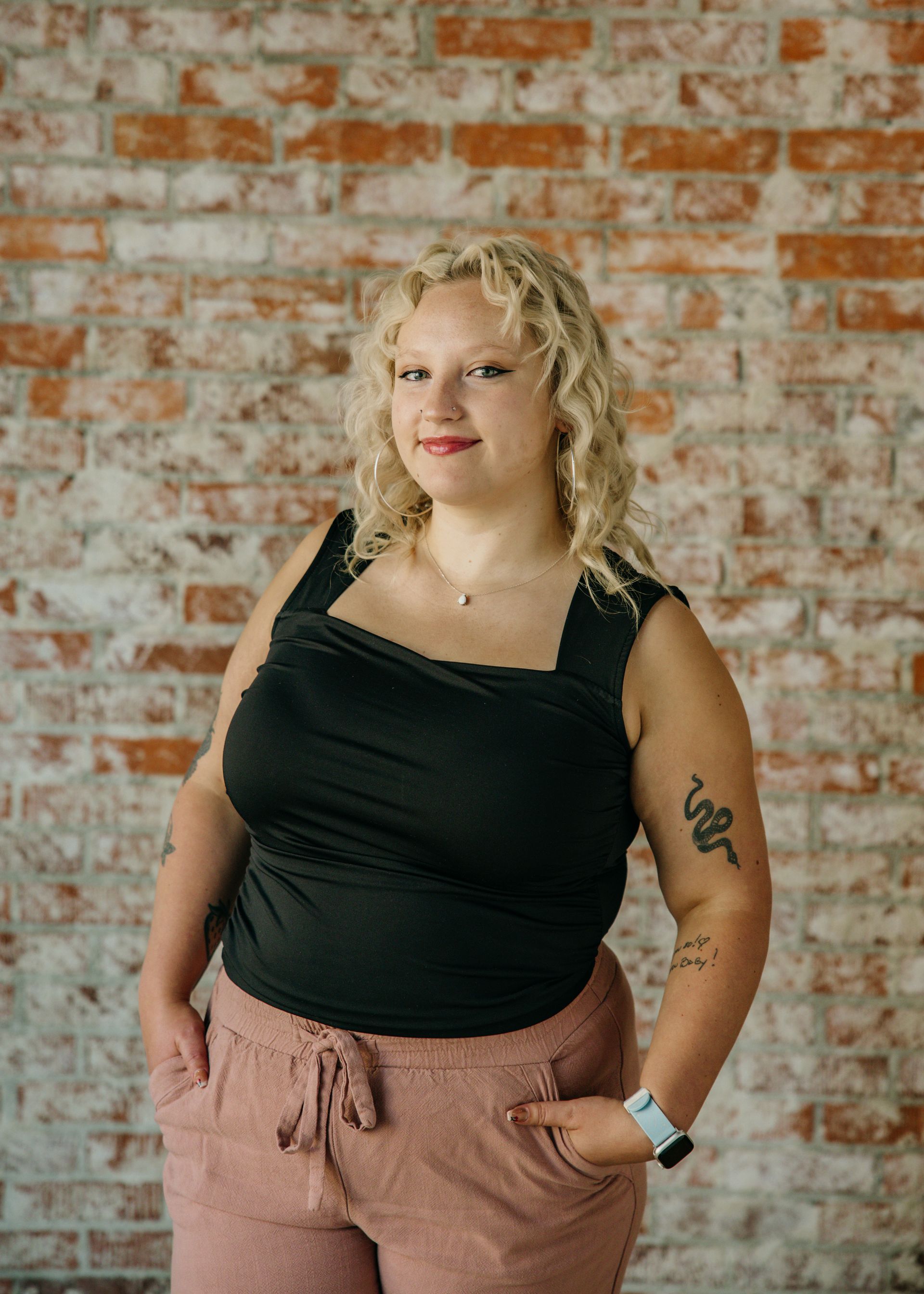 A woman with blonde hair and a necklace is smiling for the camera.