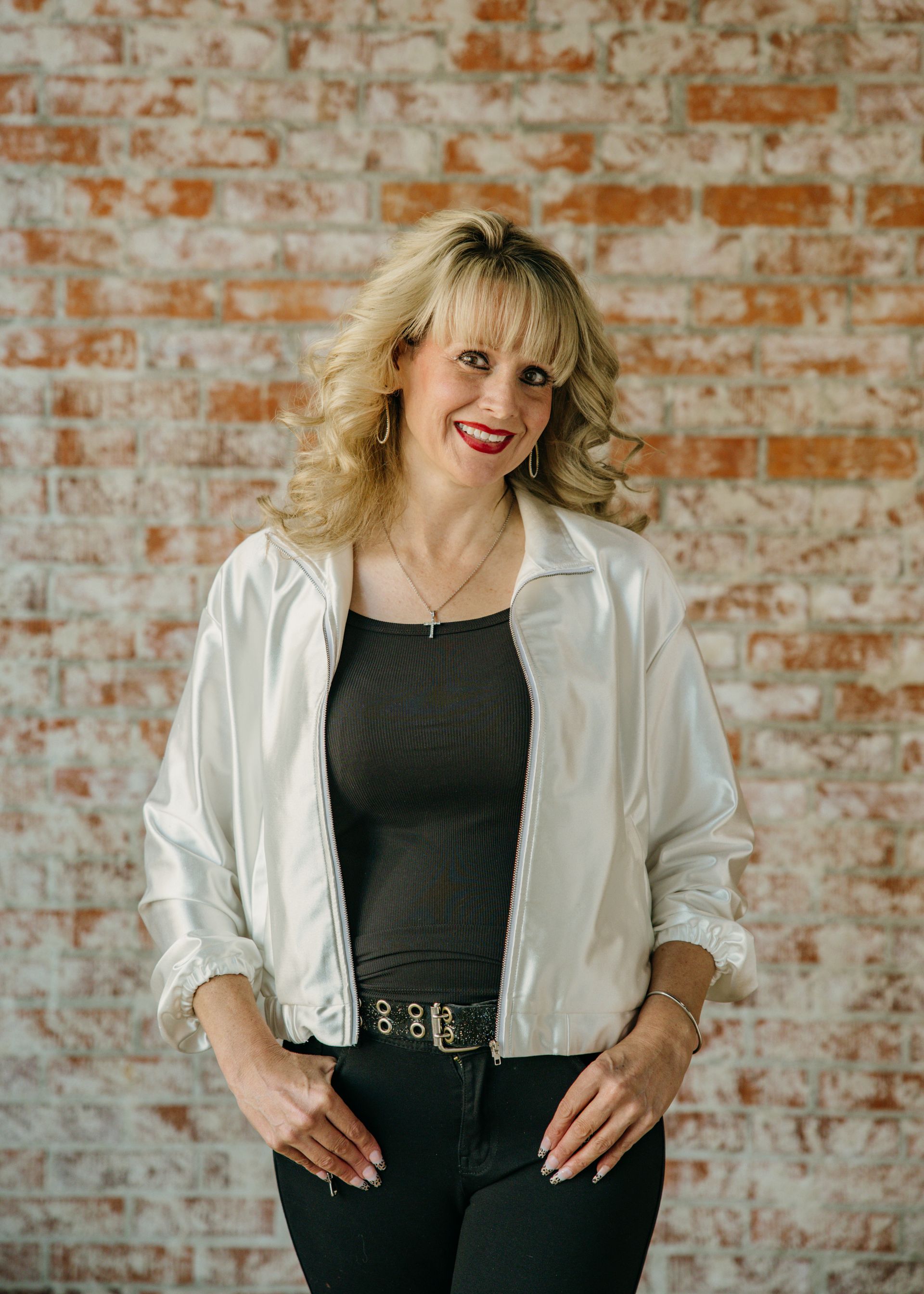A woman in a black suit is standing next to a body of water.