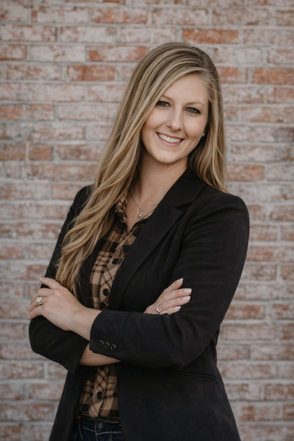 A woman in a black suit is standing next to a body of water.