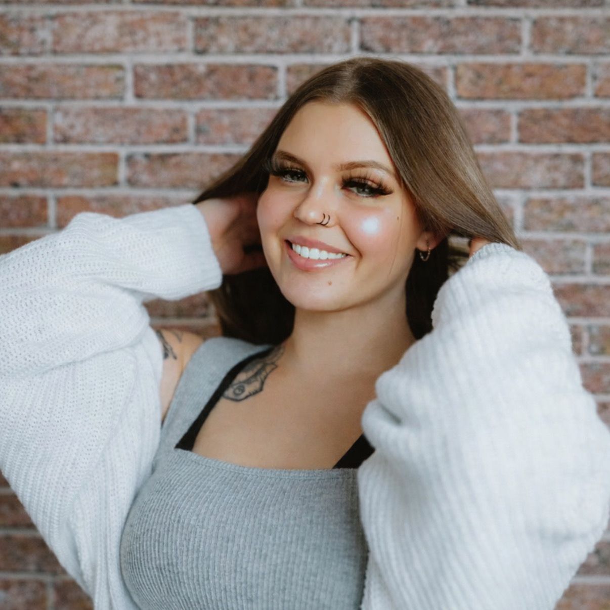 A woman in a black top and white skirt is standing next to a river.