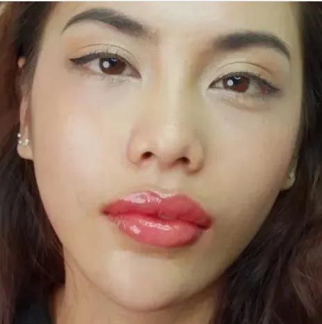 A close up of a woman 's face with red lips.