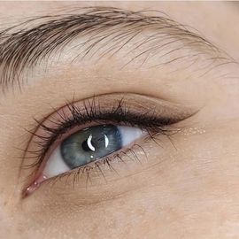 A close up of a woman 's eye with long eyelashes.