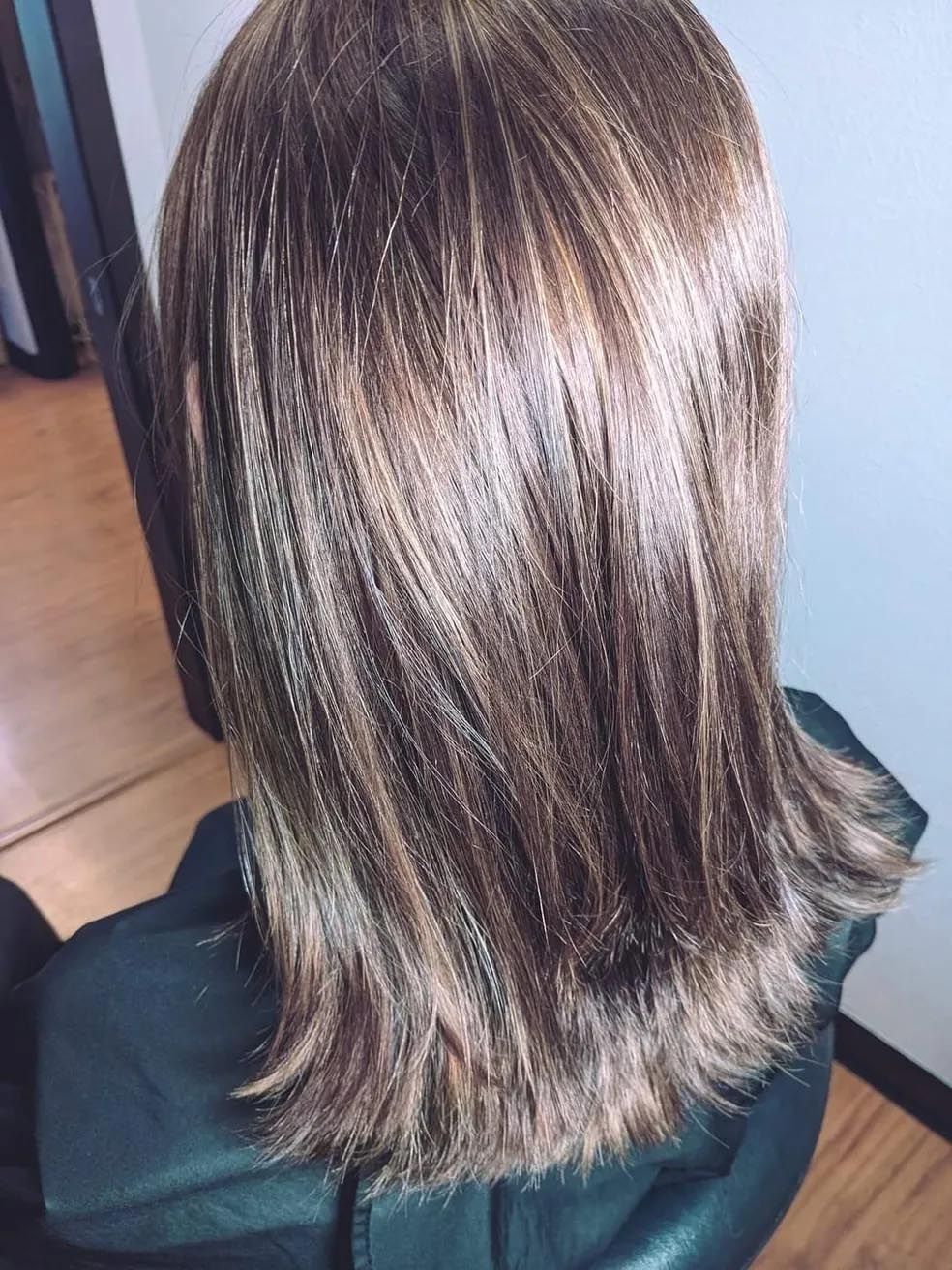 A woman is sitting in a chair with her hair in a ponytail.