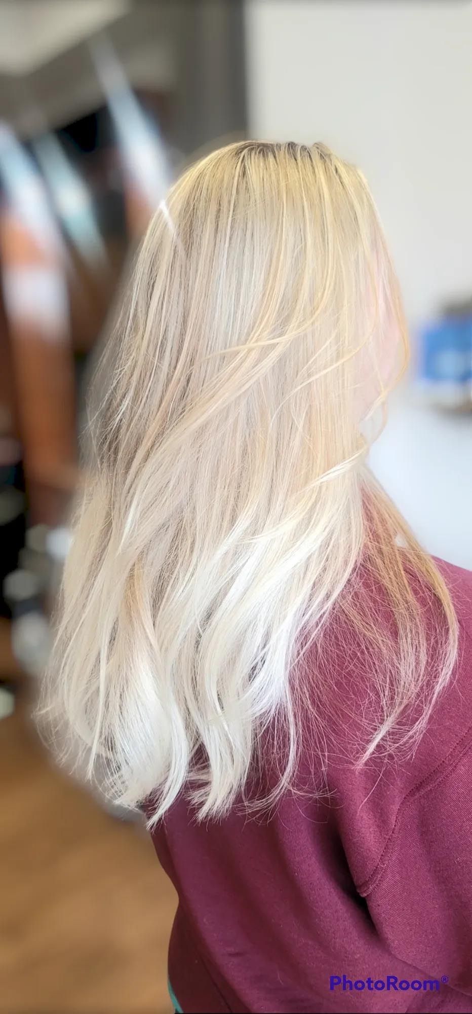 A woman with blonde hair is wearing a red sweater.