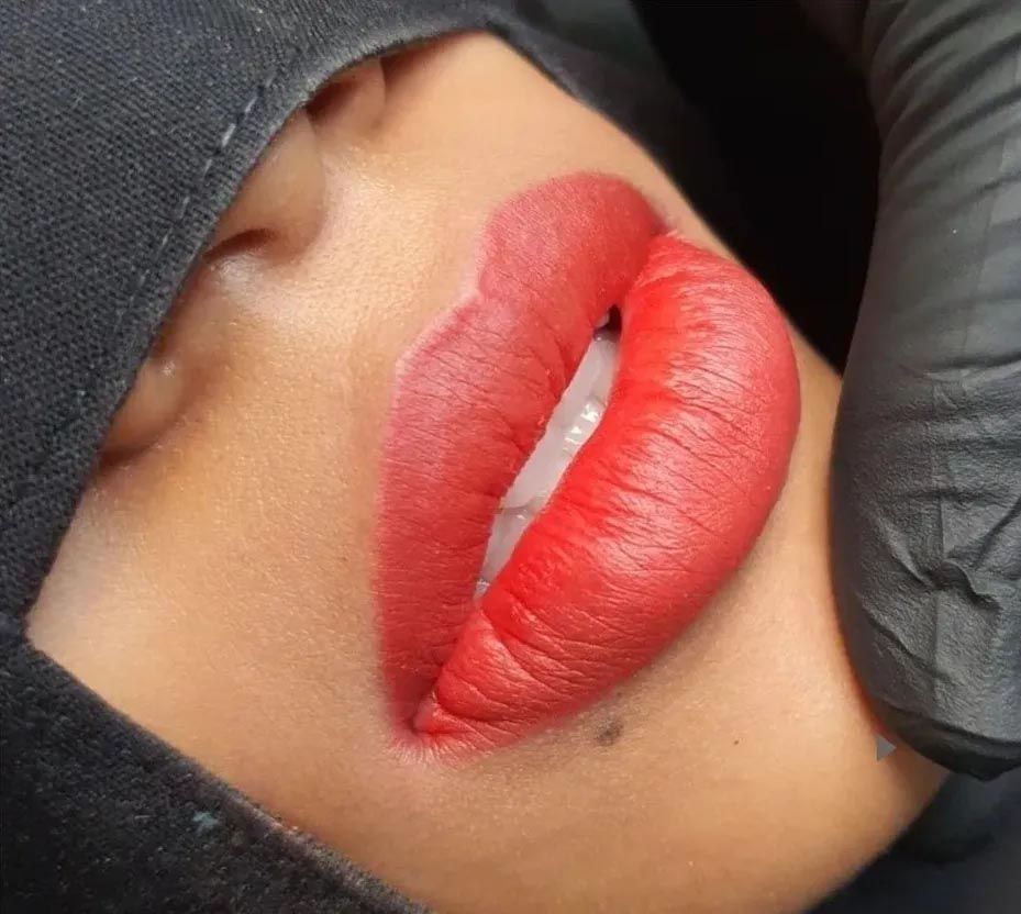 A close up of a woman 's lips with red lipstick