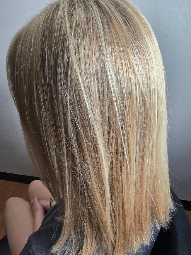 A woman with blonde hair is sitting in a chair.