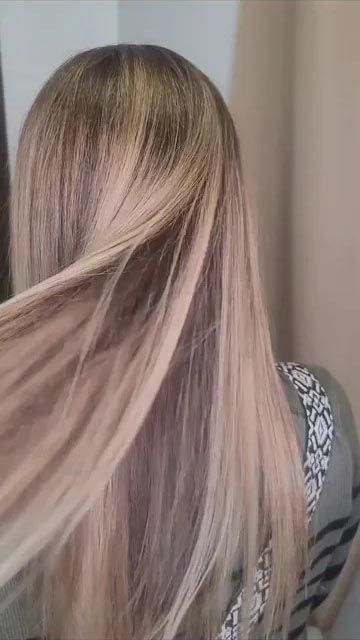 A woman with long blonde hair is standing in front of a mirror.