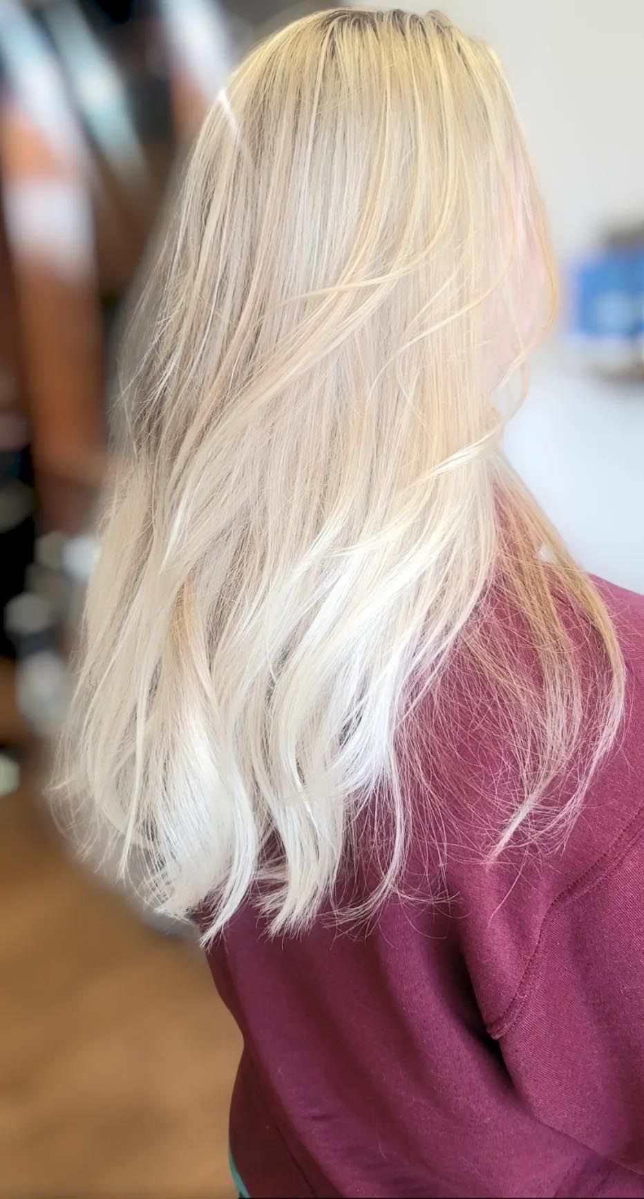A woman with blonde hair is wearing a red sweater.
