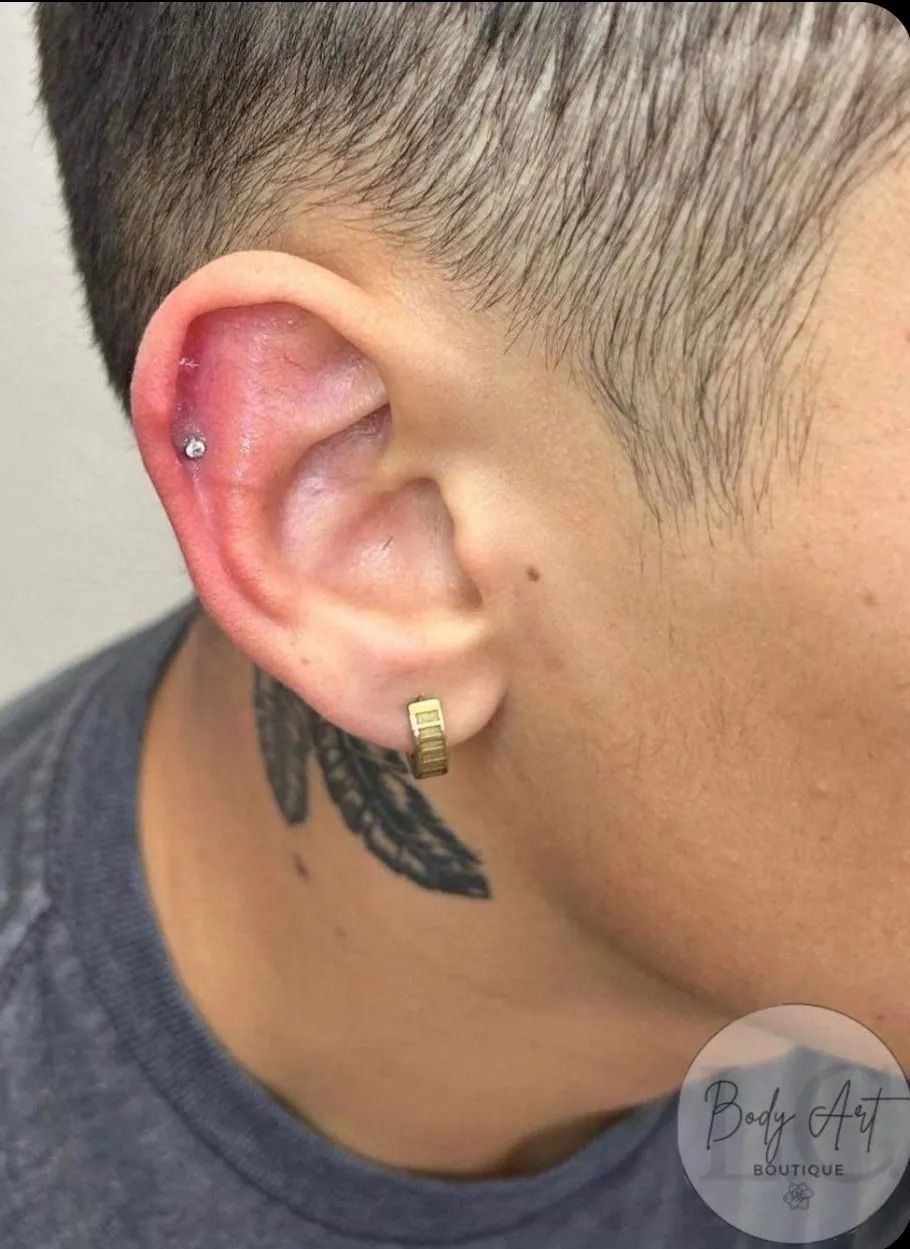 A close up of a man 's ear with a tattoo on his neck