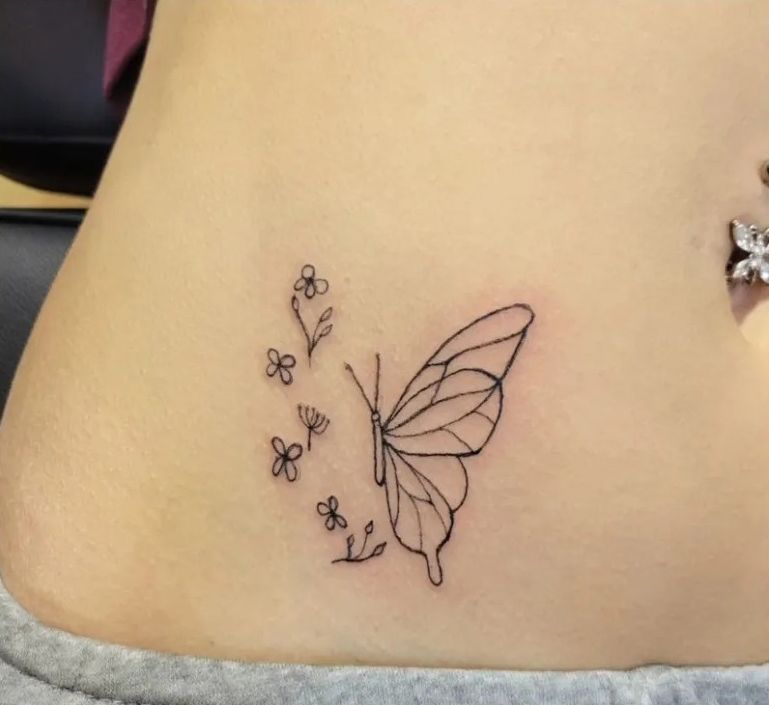 A woman has a tattoo of a butterfly and flowers on her stomach