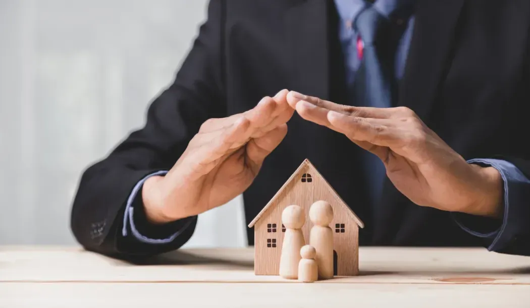 Green highway sign reading Protecting Your Assets against an orange sunset sky