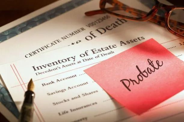 Estate documents with a red Probate note and eyeglasses on top