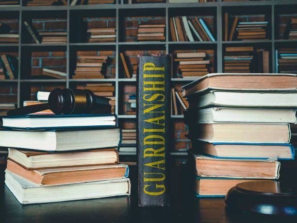 Stacks of books around a vertical GUARDIANSHIP book in a library-like setting.