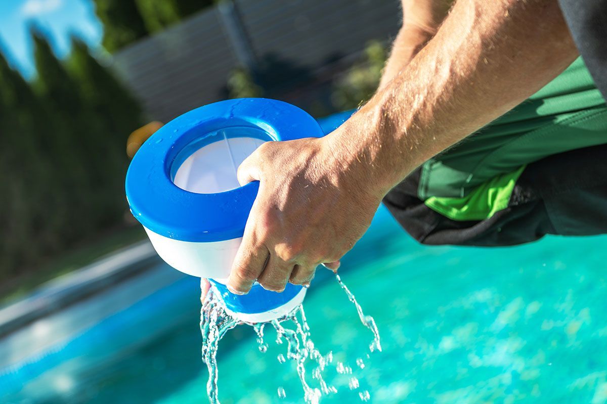 Men Removing Chemical Dispenser From His Pool To Load New Chlorine Tables