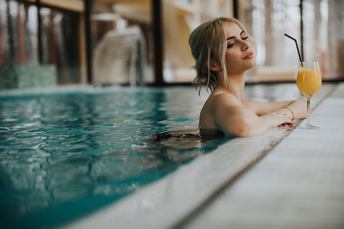 young blonde woman relaxing on the poolside