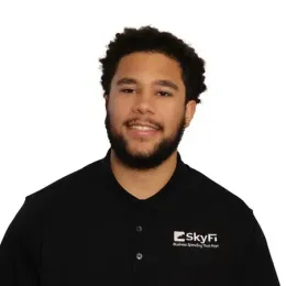 A man with a beard is wearing a black shirt that says skyfi on it.