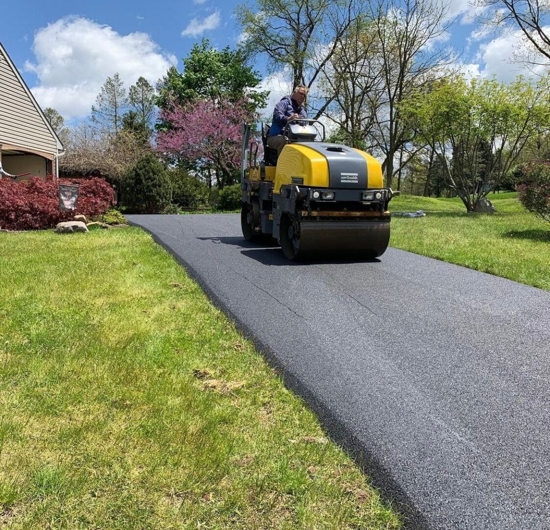 A yellow and black roller is driving down a road.