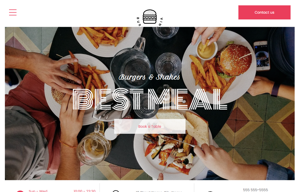 A group of people are sitting at a table eating hamburgers and french fries.
