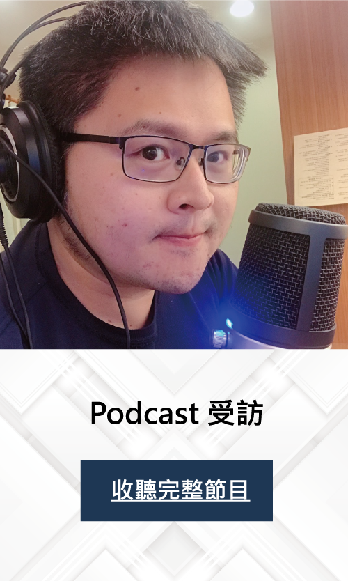 A man wearing glasses and headphones is standing in front of a microphone.