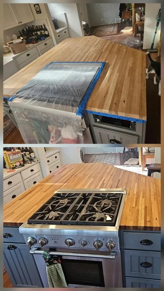 Kitchen with wood island countertop, blue cabinets, and a stainless stove under installation, partly wrapped in plastic