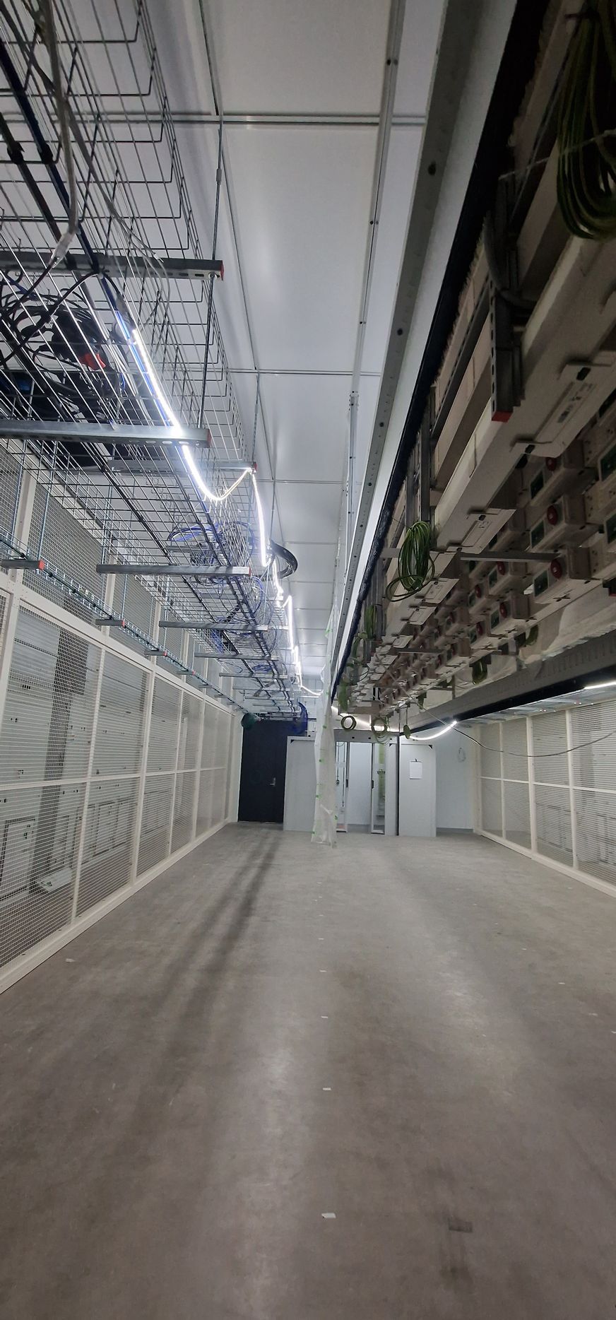 Et tomt lager med mange ledninger hengende i taket.