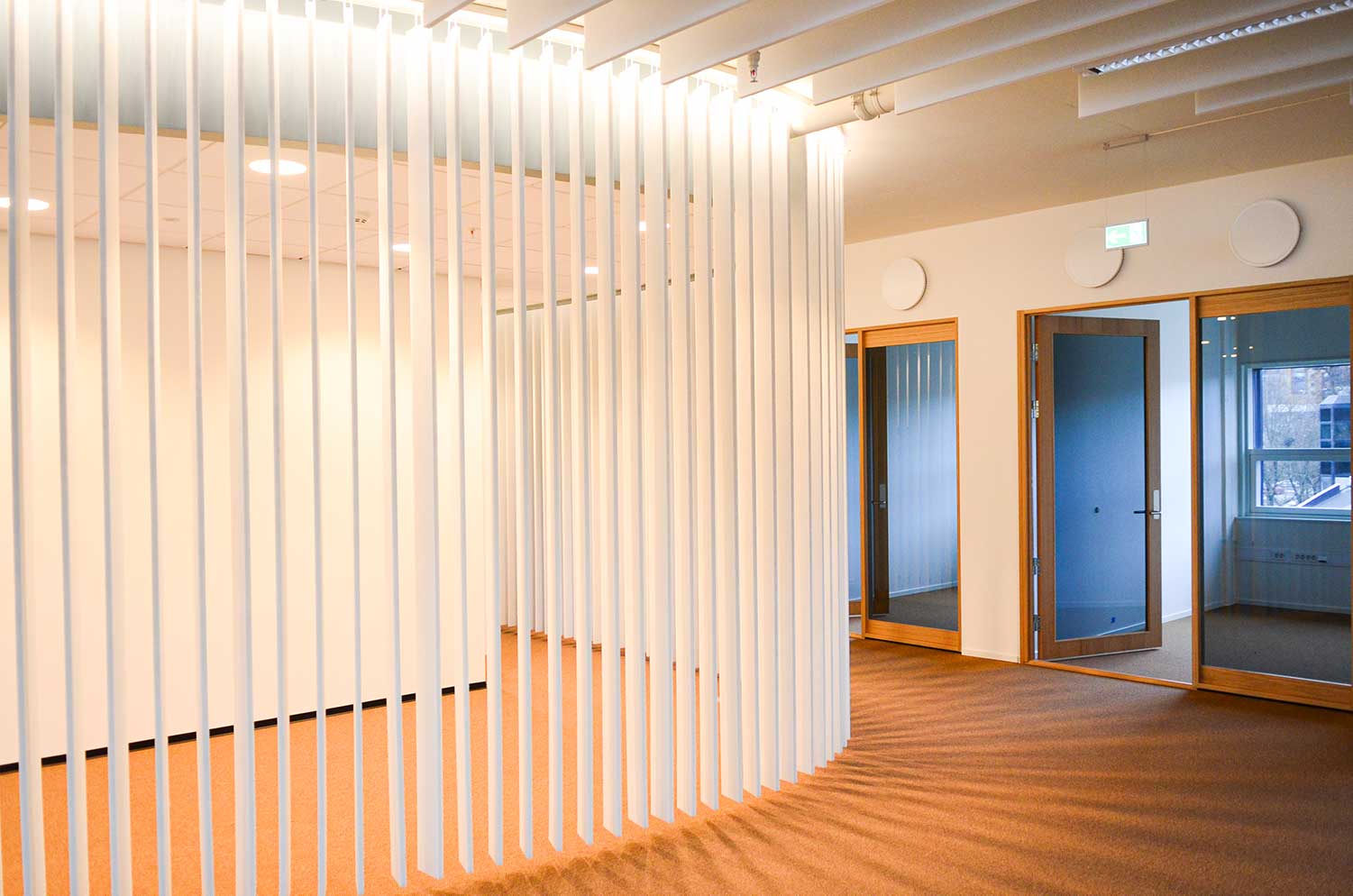 Et tomt rom med en hvit vegg og et tregulv.