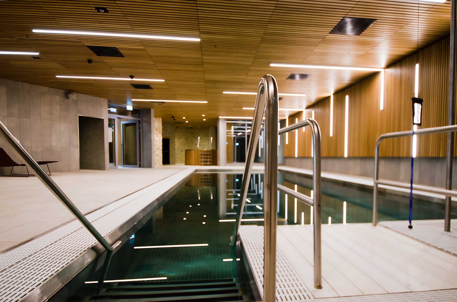 Et stort innendørs svømmebasseng med trapper som fører til det.