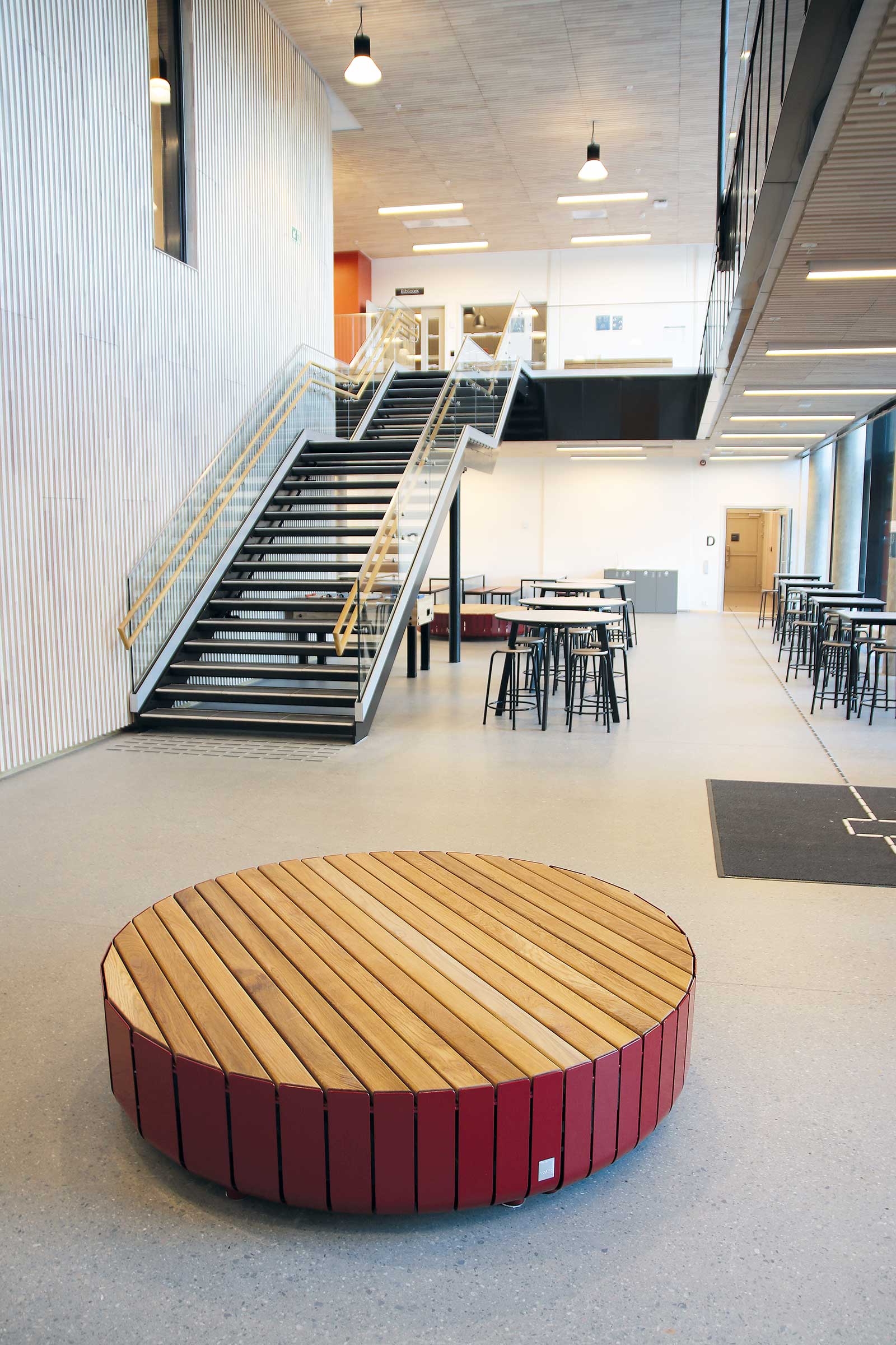 Det er et rundt trebenk midt i rommet og en trapp.