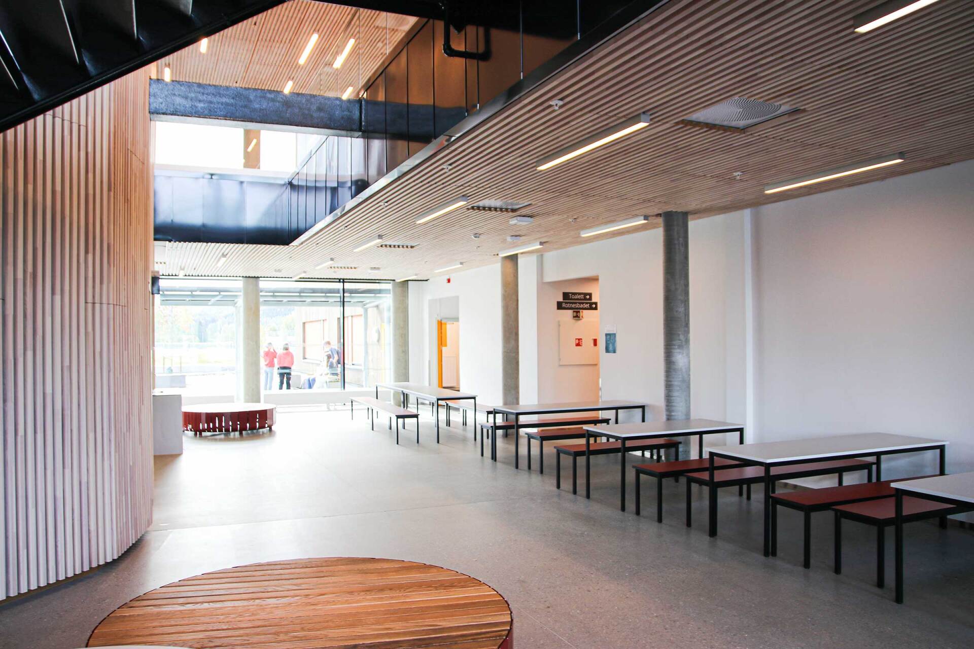 Et stort rom med bord og benker i