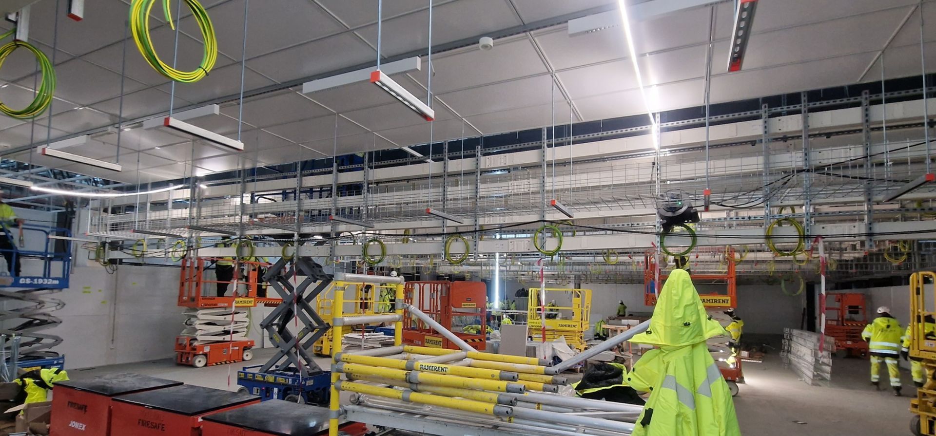 En gruppe bygningsarbeidere jobber i et stort rom.