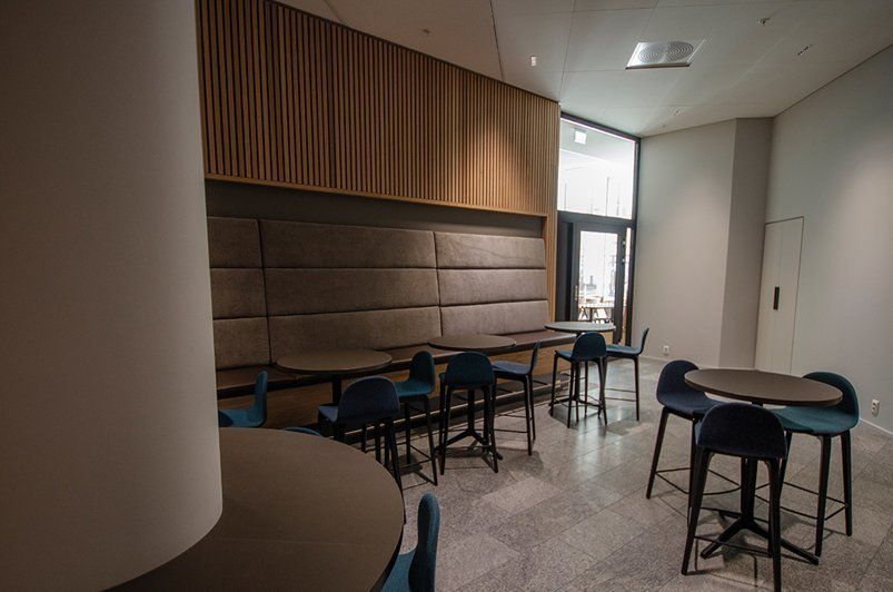 Det er mange bord og stoler i dette rommet.