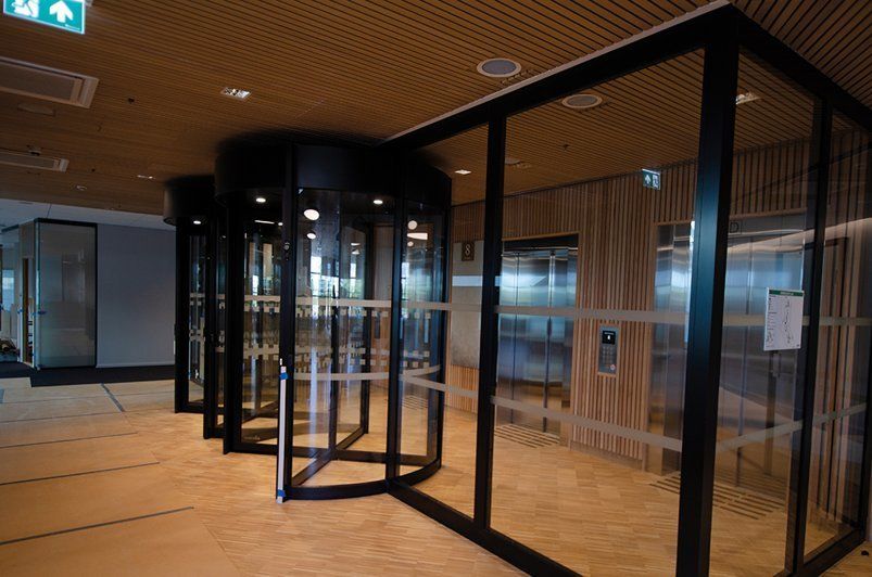 Et bygg med mye glassdører og grønt utkjøringsskilt.