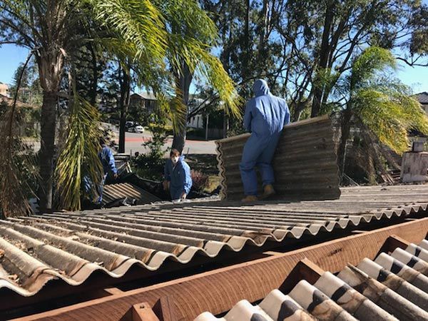 A man in a blue suit is standing on top of a roof.