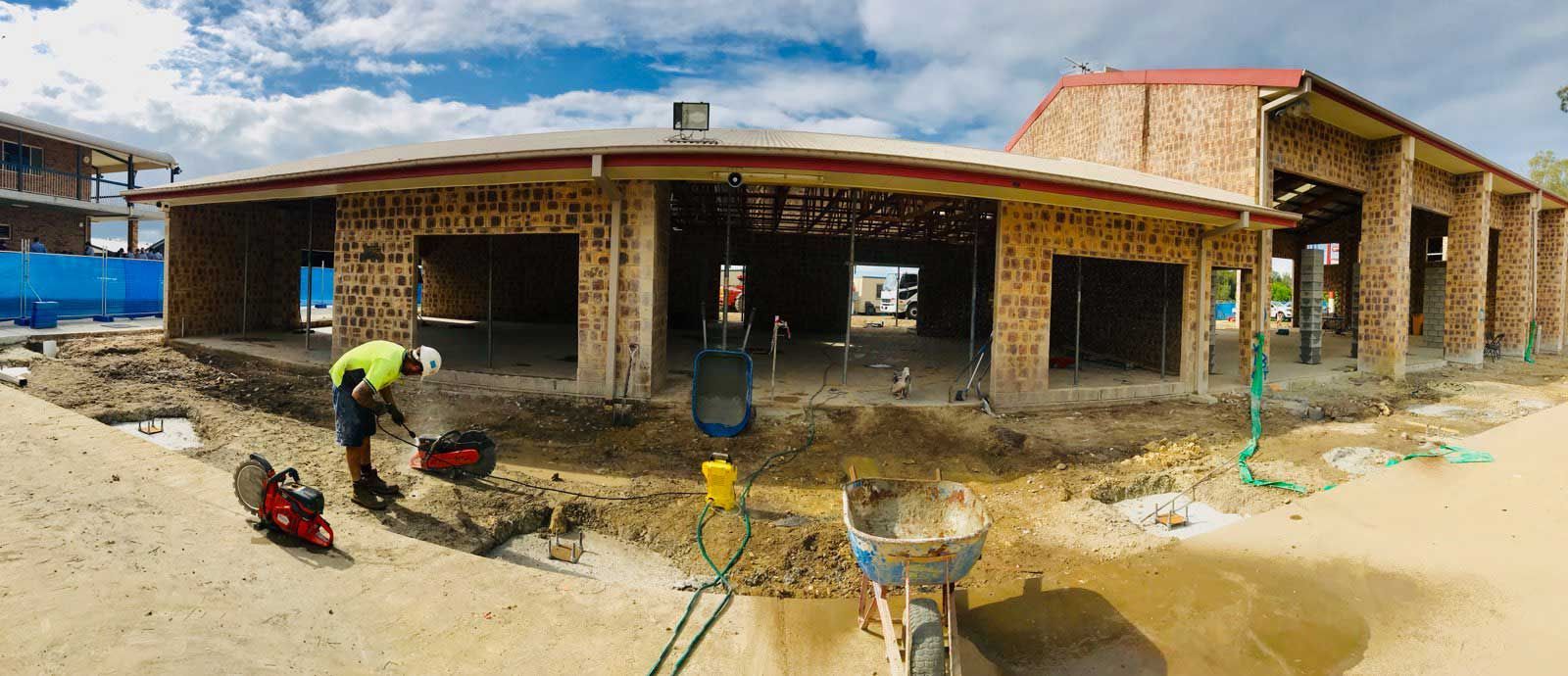 A man is standing in front of a building under construction.