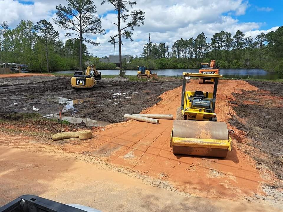 Construction site with yellow machinery working on a muddy area.