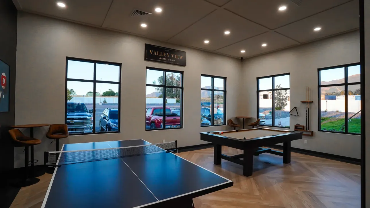 A game room with a pool table and ping pong table.