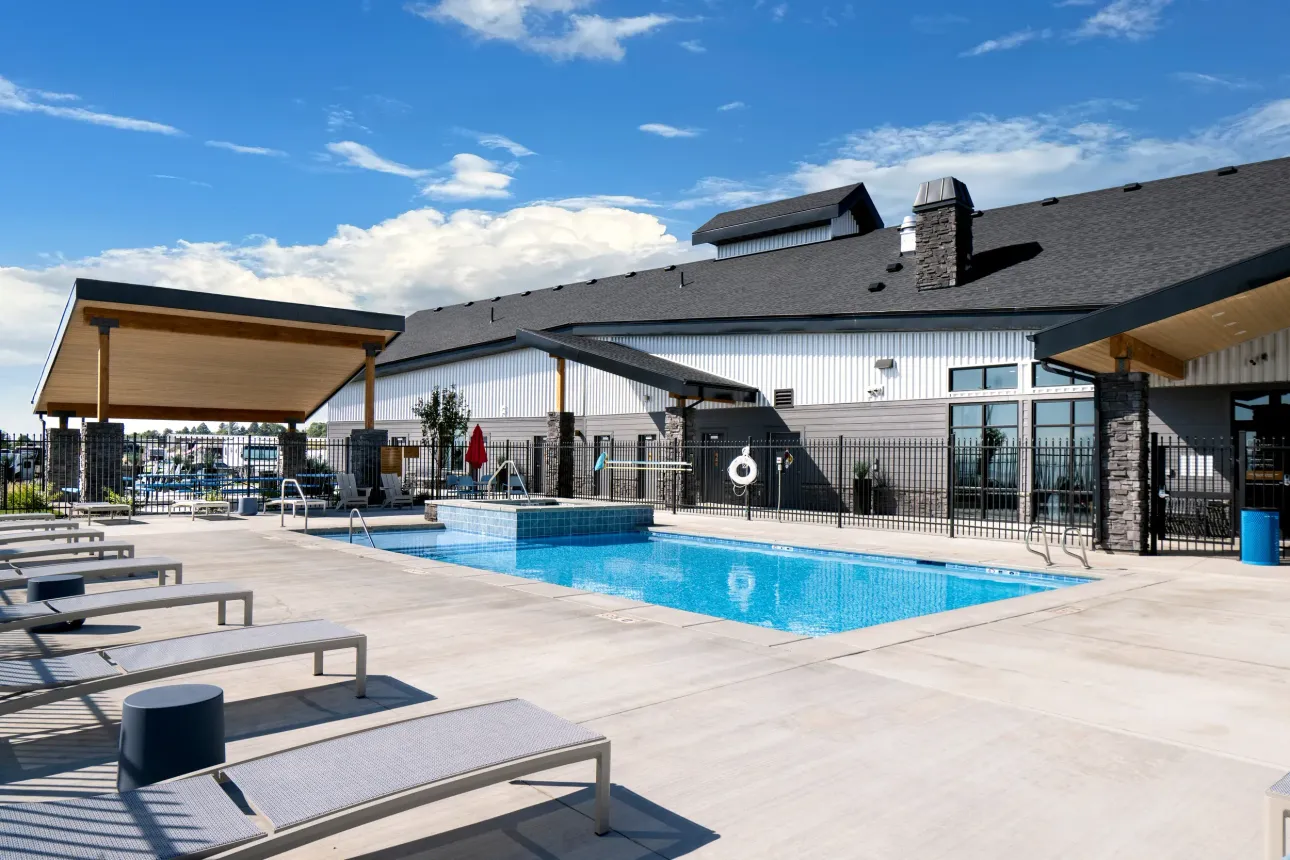 There is a large swimming pool in front of a building.