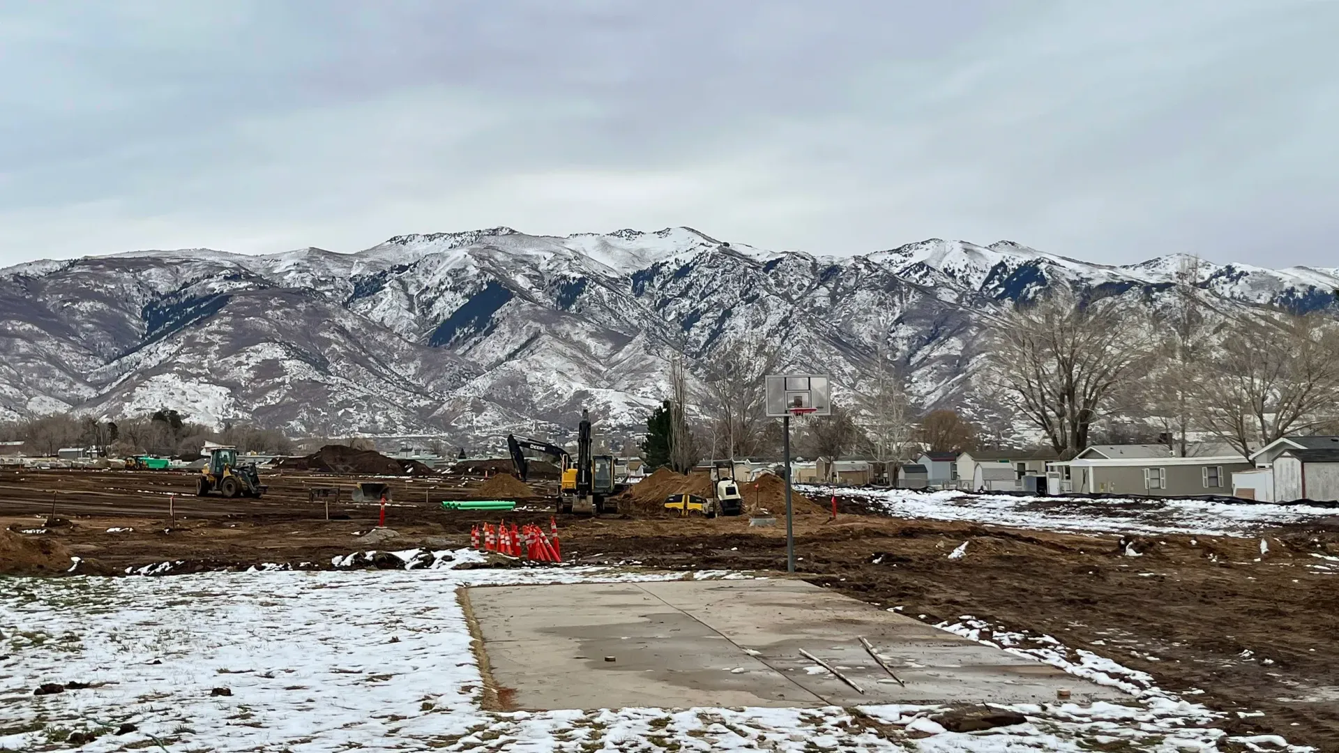 There is a lot of snow on the ground and mountains in the background.