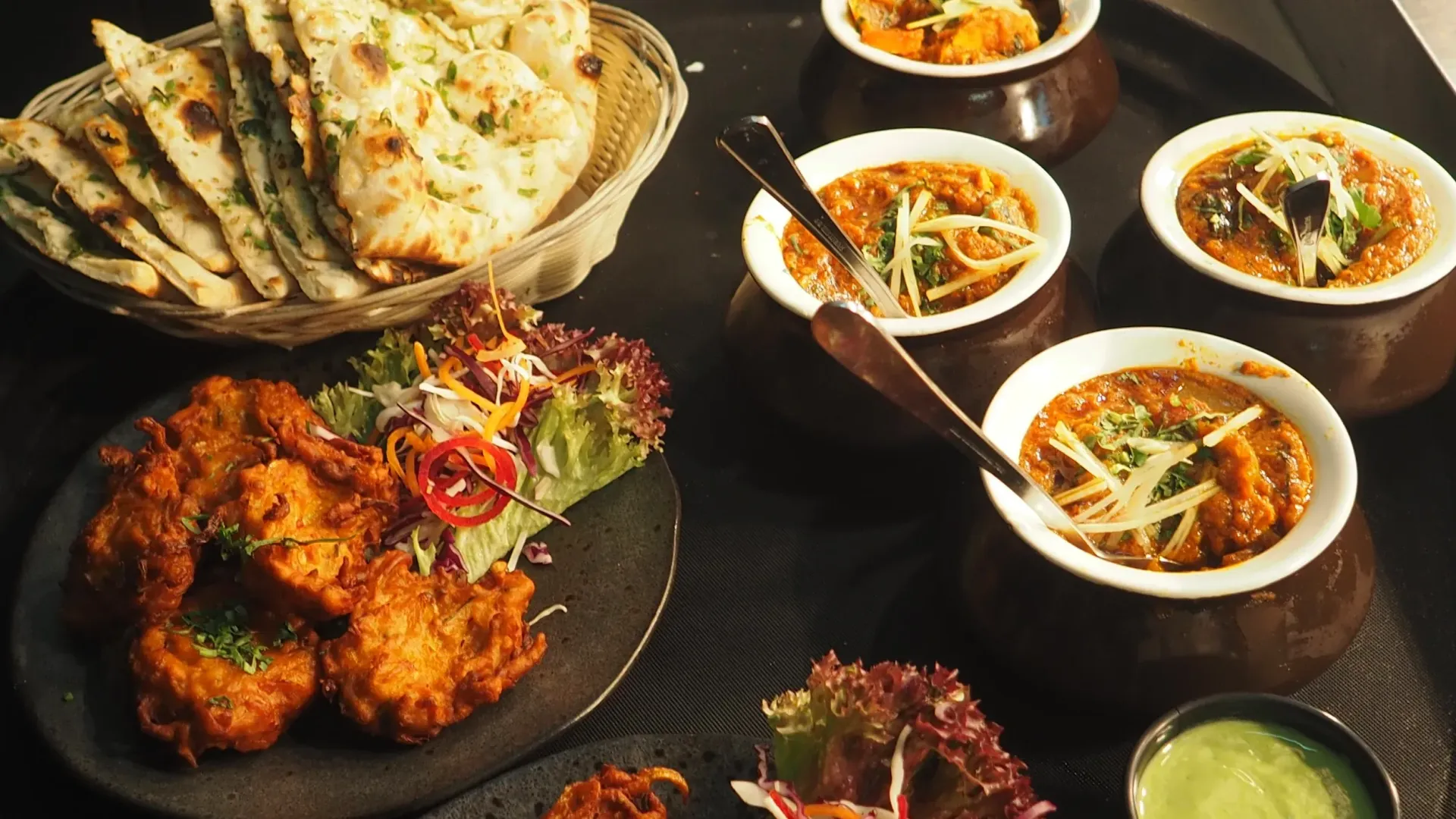 A table topped with plates of food and bowls of soup.