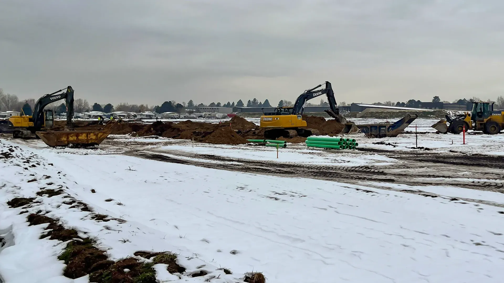 A construction site with a lot of machinery in the snow.