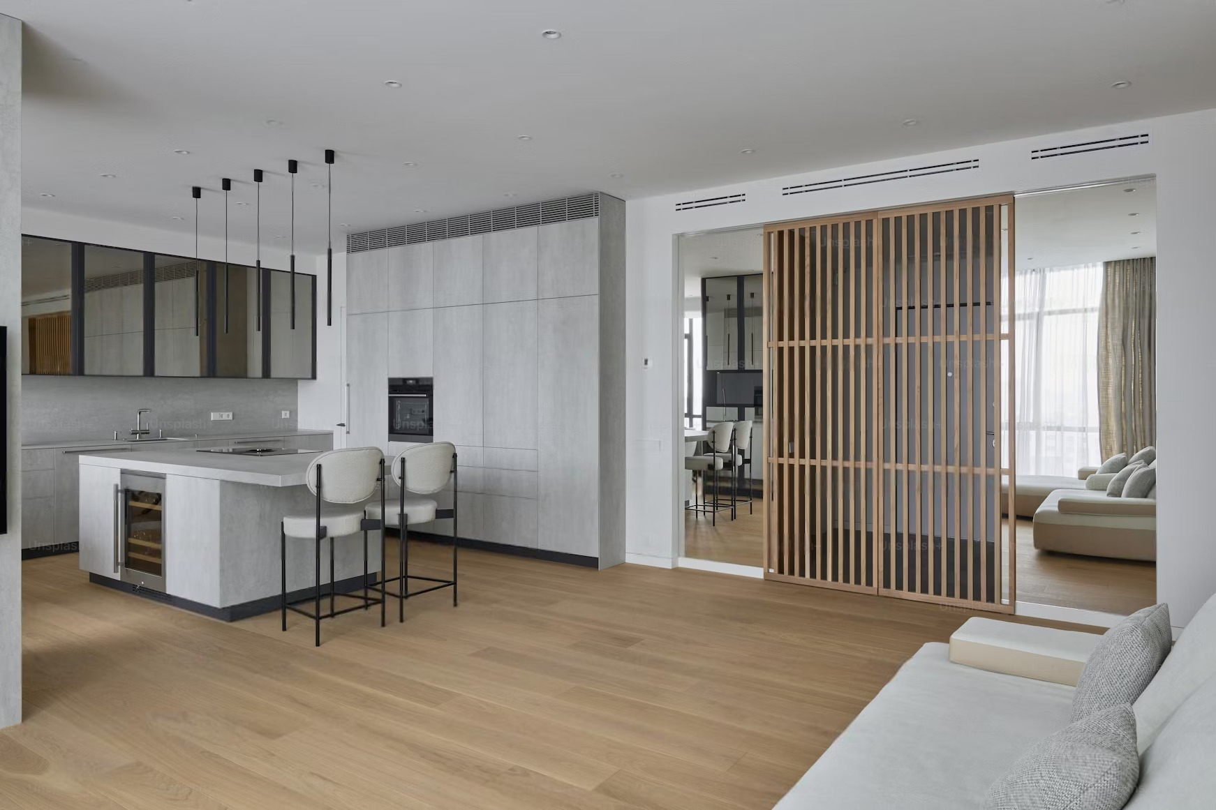 a living room with a kitchen , dining room , and sliding glass doors .