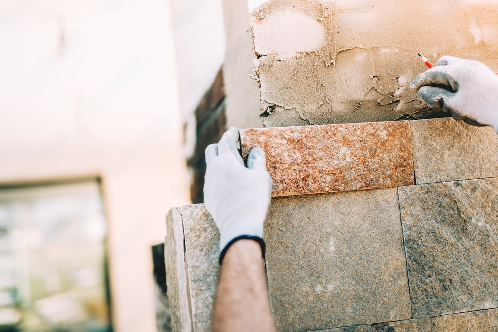 a person is laying bricks on a wall .