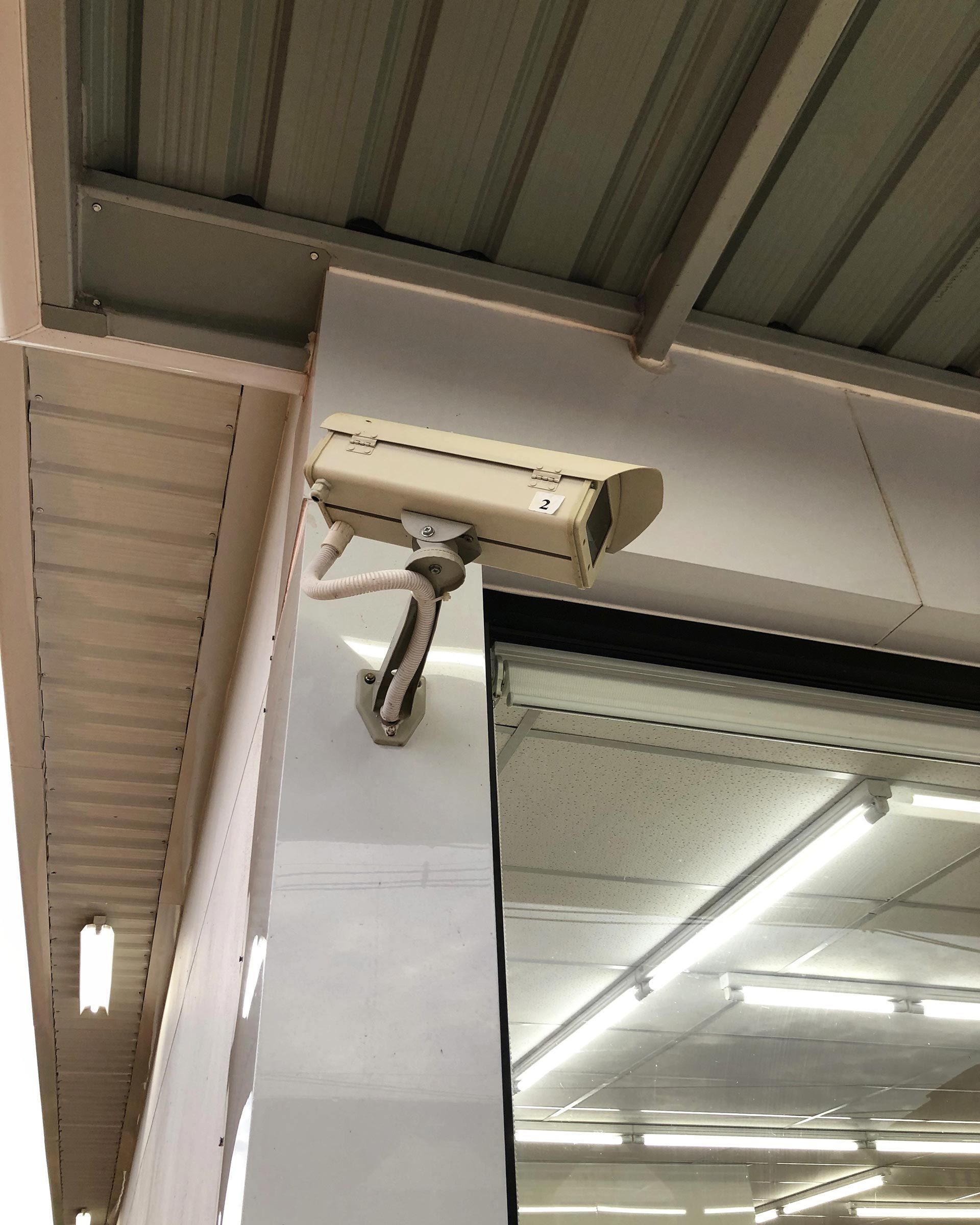 A security camera is mounted on the side of a building