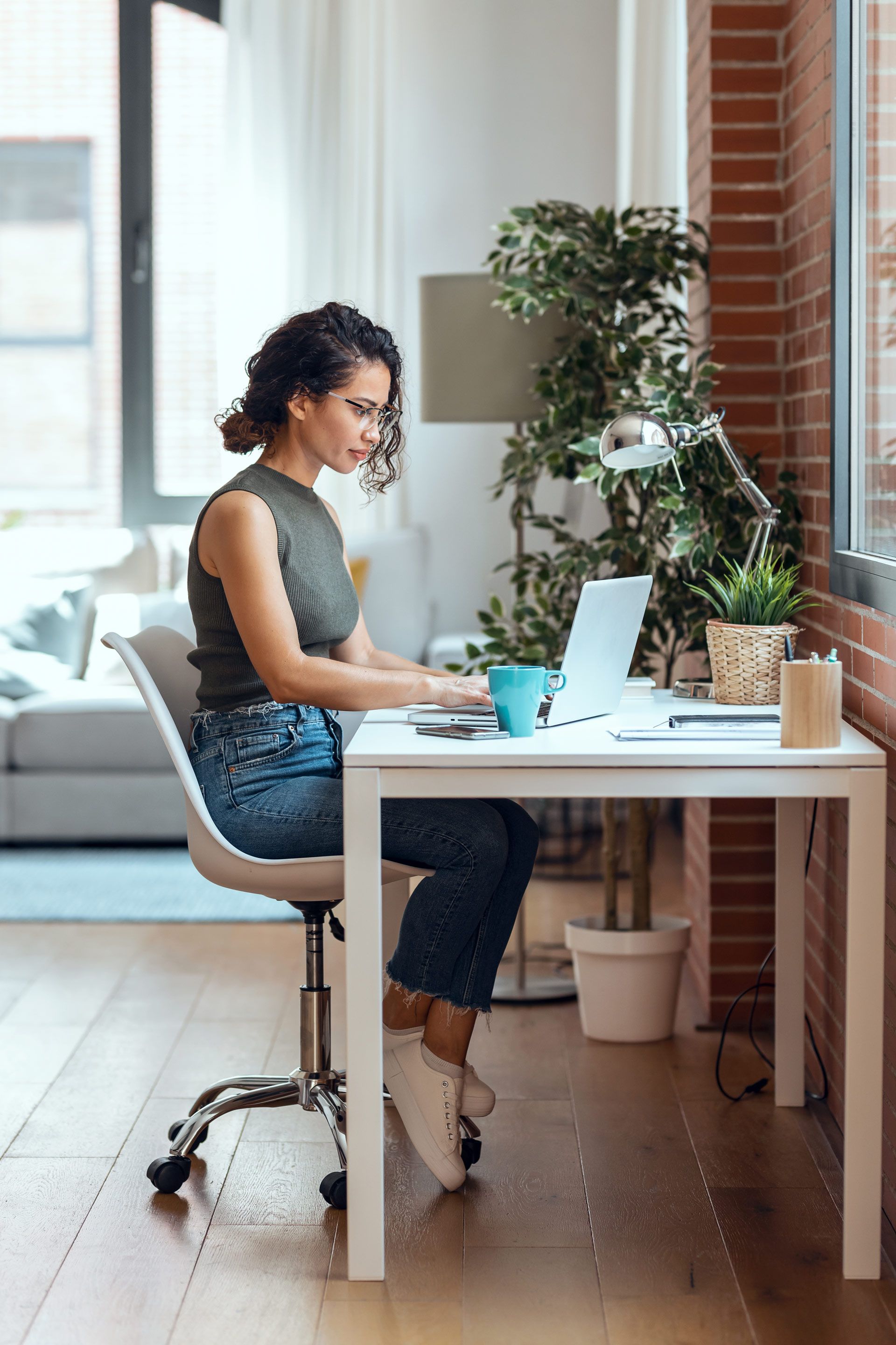 A woman is sitting at a desk using a laptop computer