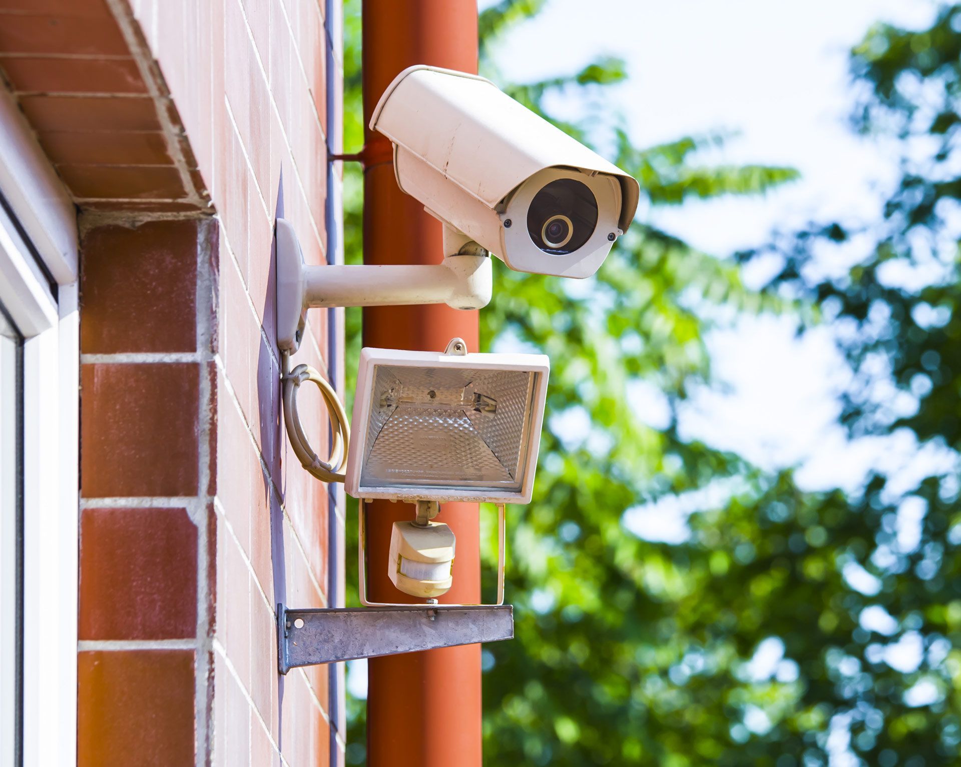 A security camera is mounted on the side of a building