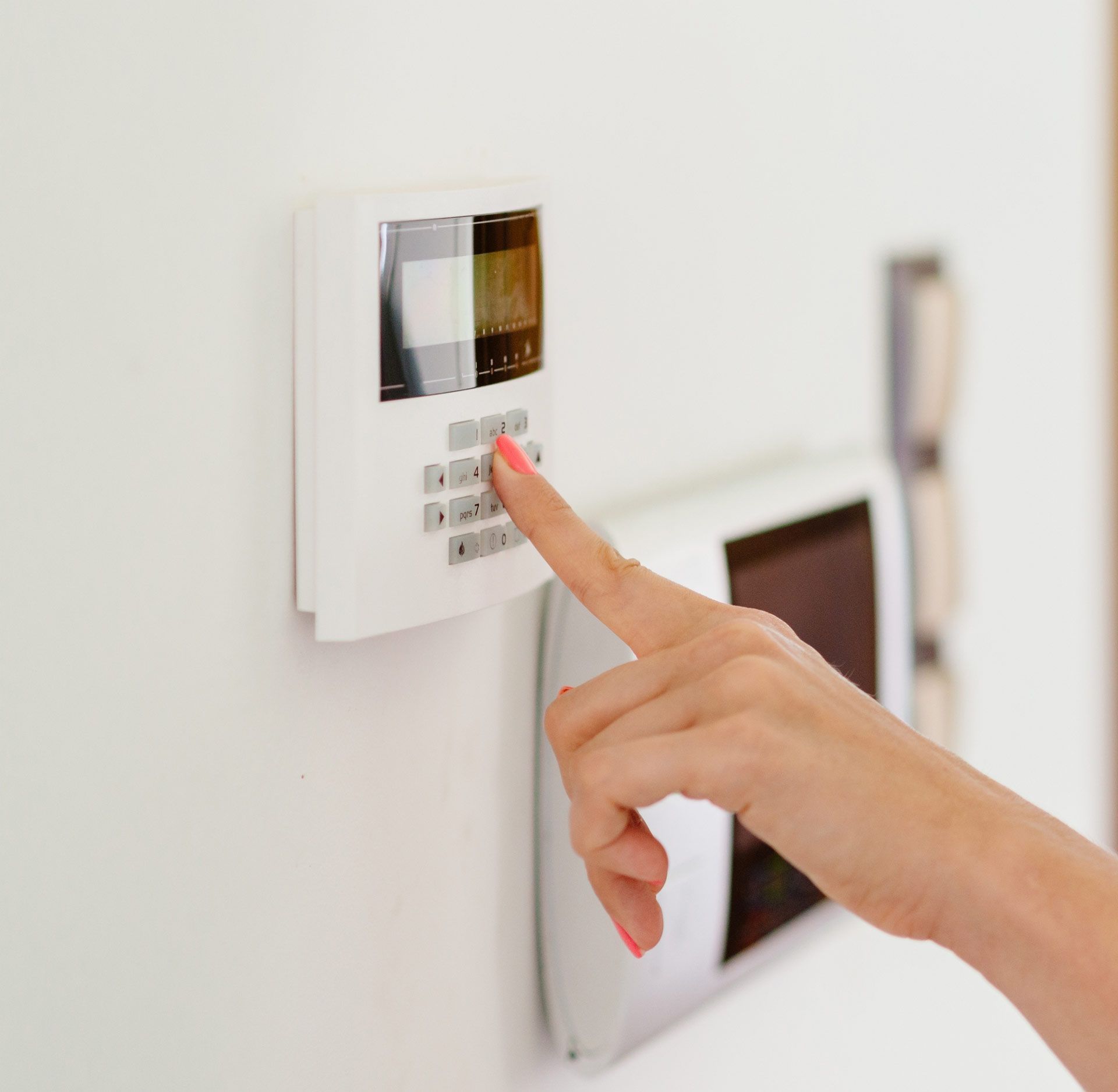 A woman is pressing a button on a security system.